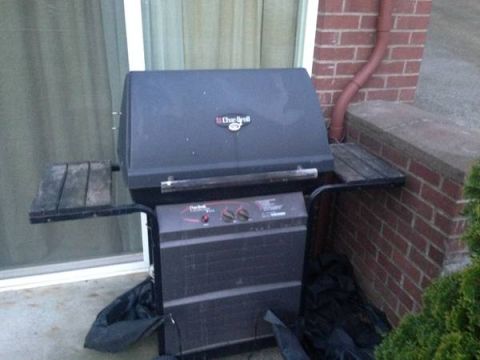 2008 Ford F-250 - A gas grill sits on a patio next to a brick wall and a window.
