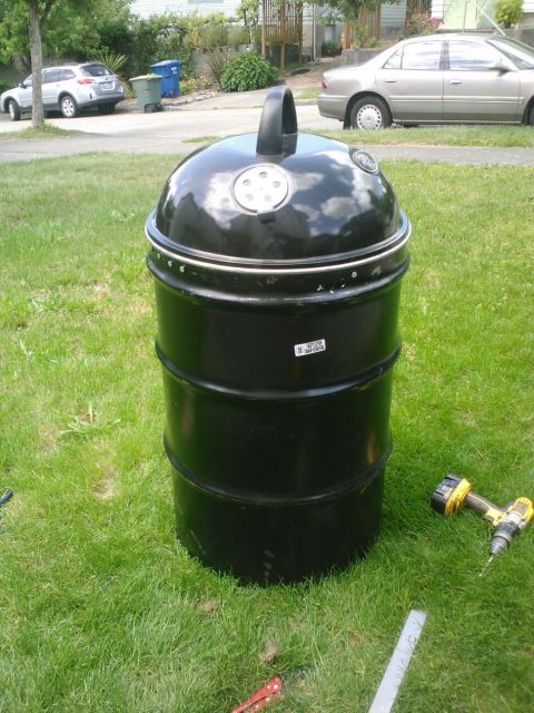 2008 Ford F-250 - A black barrel smoker sits on a grassy lawn, with a power drill and ruler nearby.