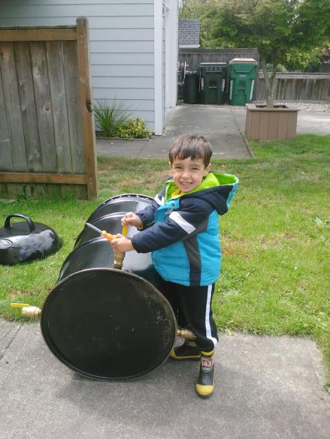 2008 Ford F-250 - A young boy smiles while holding a tool near a barrel in a grassy yard.