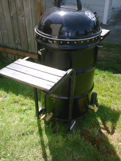 2008 Ford F-250 - A black smoker grill with two wooden side shelves and two brass spigots is shown outdoors on a grassy area.