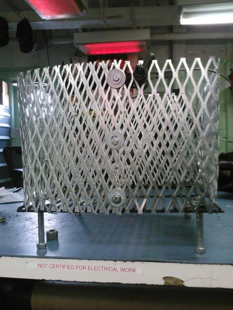 2008 Ford F-250 - A metal cage sits on a table under red heat lamps, with a warning label visible.