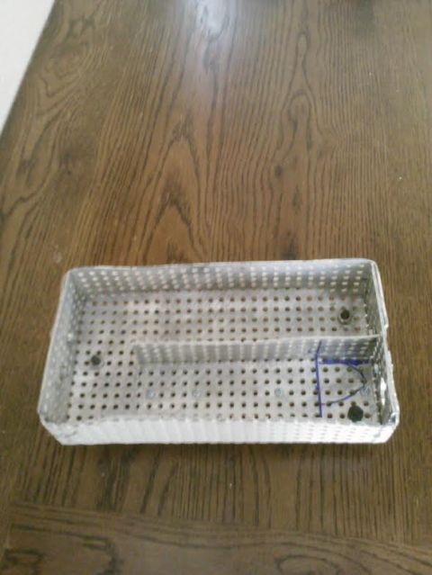 2008 Ford F-250 - A perforated metal tray, possibly for medical instruments, sits on a wooden surface.