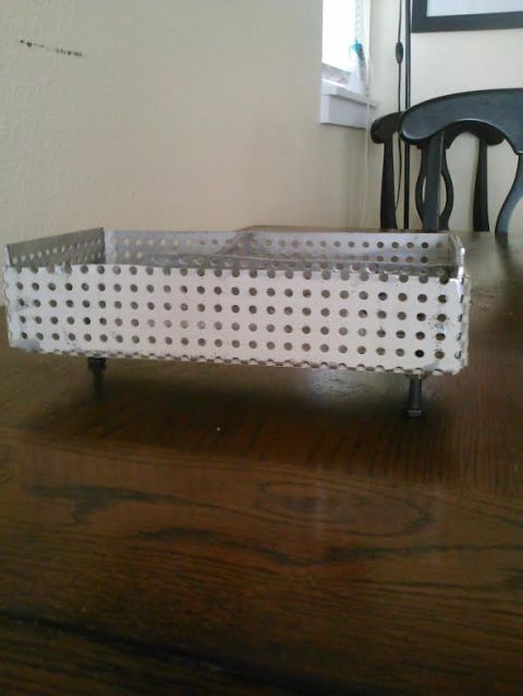 2008 Ford F-250 - A metal basket with many small holes sits on a wooden table, with a chair and window in the background.