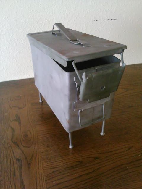 2008 Ford F-250 - A metal ammo can with a hinged lid and four legs sits on a wooden floor.
