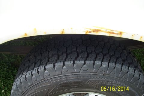 1990 Ford Bronco - Rust is visible on the fender above the tire of a white vehicle.