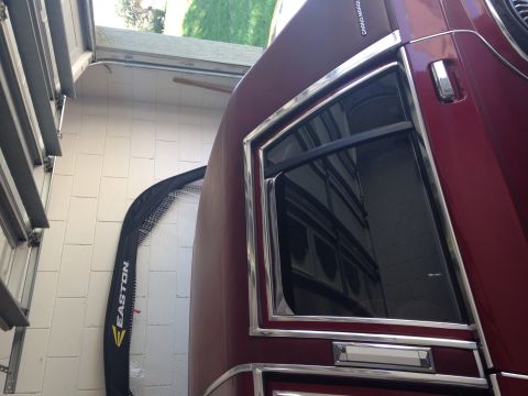 1991 Mercury Grand Marquis - A maroon 1991 Mercury Grand Marquis LS sedan is partially visible in a garage, showing its side profile with chrome accents.