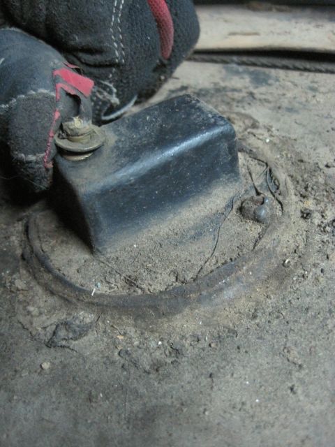 1946 Jeep CJ5 - A close-up view shows a black square part secured with a bolt and washer to a dusty surface.