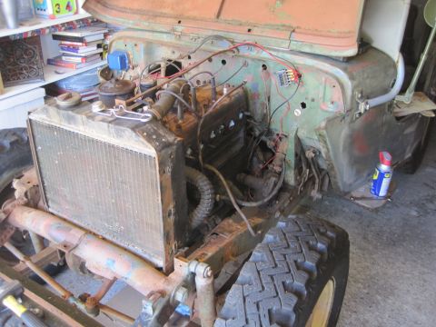 1946 Jeep CJ5 - The engine bay of a vintage Jeep shows its radiator and various mechanical components, suggesting a project vehicle.