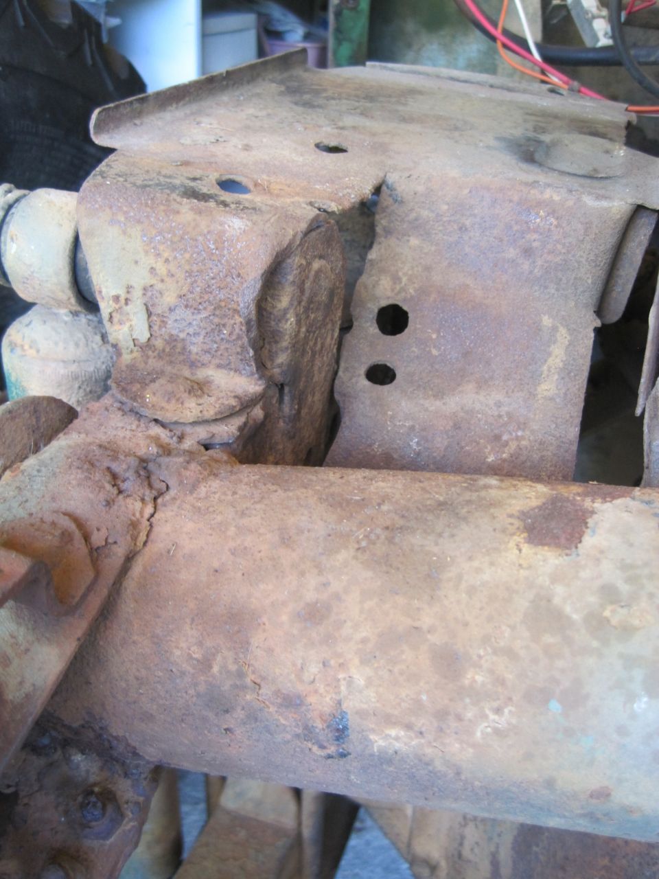 Rusted suspension part with two visible holes