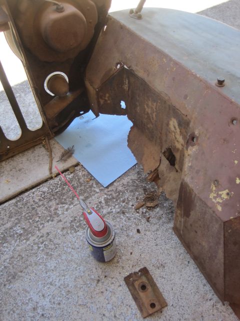 1946 Jeep Willys - A heavily rusted vehicle body panel shows significant damage and decay, with a can of lubricant nearby.