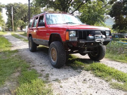 1986 Ford Bronco - This red Jeep Cherokee XJ is equipped with an aftermarket winch and bumper, suggesting off-road use.