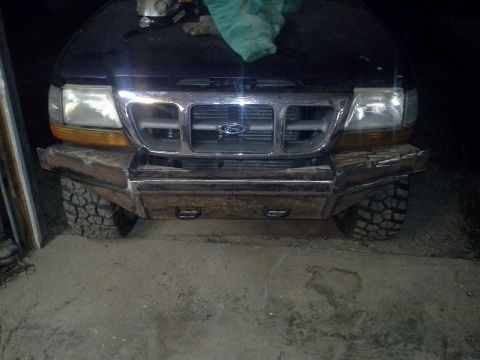 2000 Ford Ranger - A black Ford Ranger is shown from the front, a custom metal bumper and off-road tires.