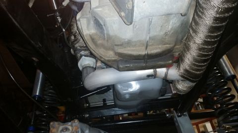 1968 Ford Bronco - Close-up of vehicle exhaust system and transmission components, showing heat wrap on pipes.