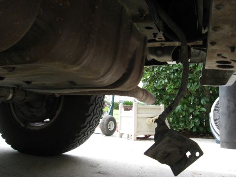 1994 Ford Bronco - The trailer hitch wiring harness hangs down from the undercarriage of the vehicle.