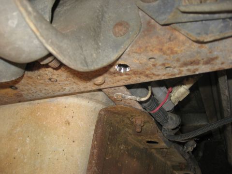 1994 Ford Bronco - Detail of rusted vehicle frame and wiring harness.