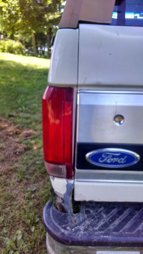 1995 Ford Bronco - The rear of a 1995 Ford Bronco is visible, the iconic Ford emblem on the tailgate.