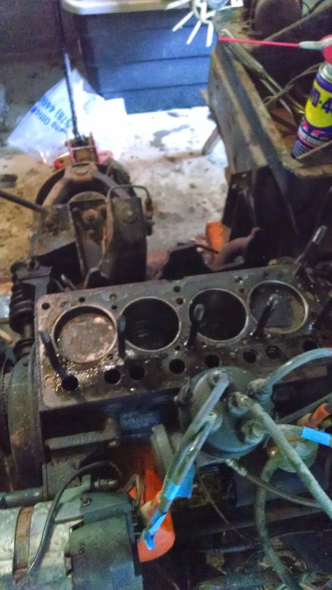 1995 Ford Bronco - Close-up of an engine block, revealing its internal structure and associated wiring, with a can of lubricant nearby.