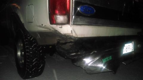 1995 Ford Bronco - The rear of a white Ford Bronco shows significant damage to its bumper and bodywork.