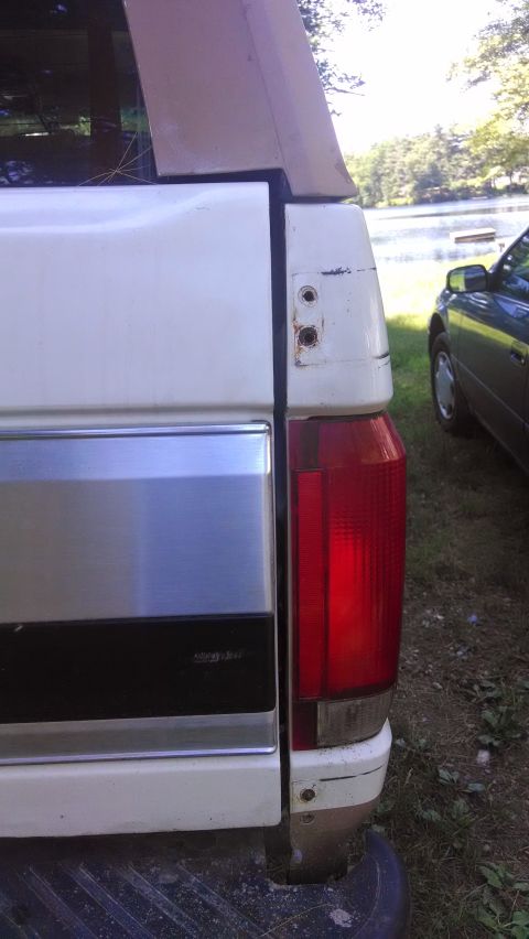 1995 Ford Bronco - Rear view of a white 1995 Ford Bronco, showing the tailgate and taillight assembly.