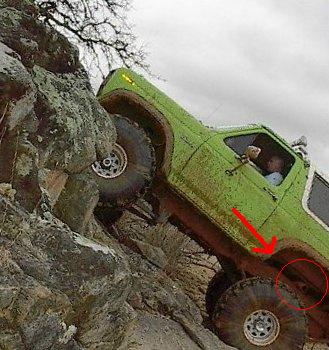 1990 Ford Bronco - A green off-road vehicle navigates a challenging rocky terrain.