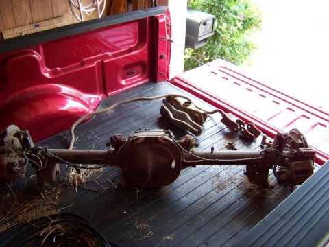 1999 Mercury Grand Marquis - Rear axle assembly and associated parts are loaded into the bed of a pickup truck.