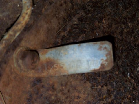 1999 Mercury Grand Marquis - A close-up view of a rusty metal component showing stamped identification numbers.