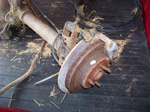 1999 Mercury Grand Marquis - This is a rusty rear axle assembly with brake components, likely removed from a vehicle.
