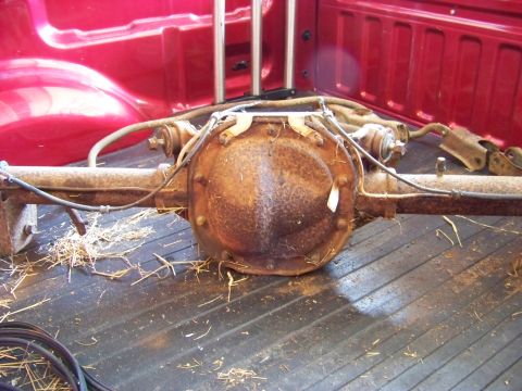 1999 Mercury Grand Marquis - A rusty rear axle assembly is shown in the bed of a red pickup truck.