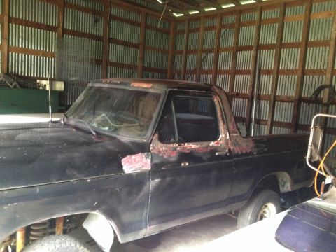1978 Ford Bronco - This 1978 Ford Bronco is stored in a corrugated metal barn, showing signs of wear and tear.