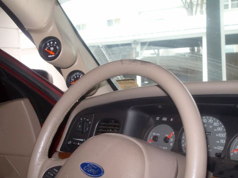 2004 Ford Crown Victoria - Aftermarket gauges are installed in the interior of the vehicle, showing oil pressure and voltage.