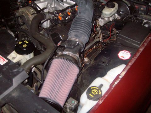 2004 Ford Crown Victoria - Aftermarket air intake system installed in an engine bay, with various hoses and reservoirs visible.