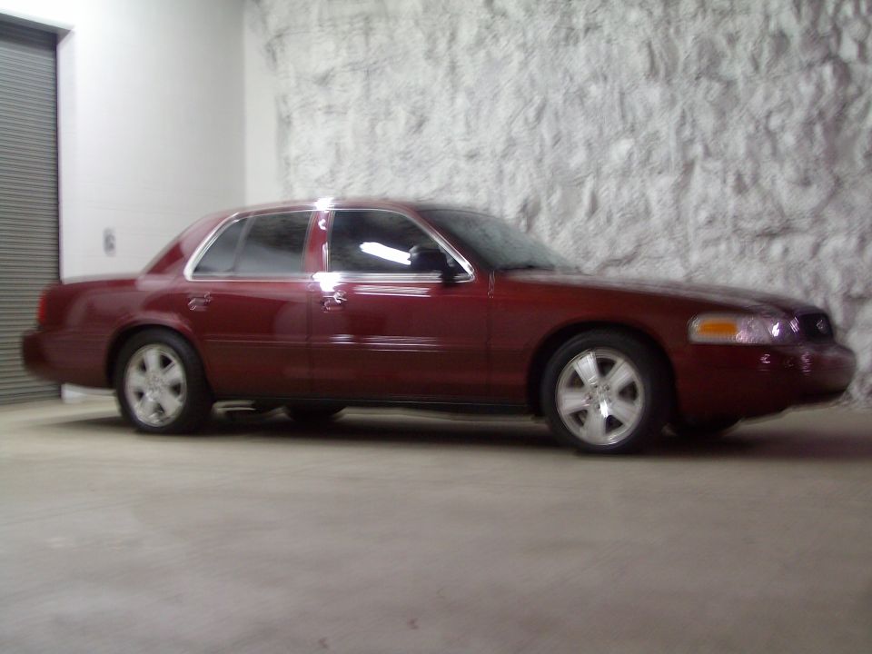 Red 2004 Ford Crown Victoria sedan, side view