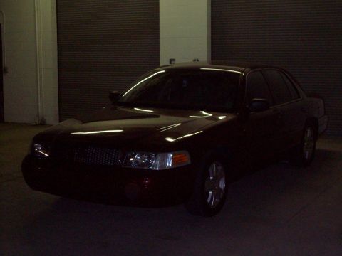 2004 Ford Crown Victoria - A dark-colored sedan is parked indoors, with its front quarter visible.