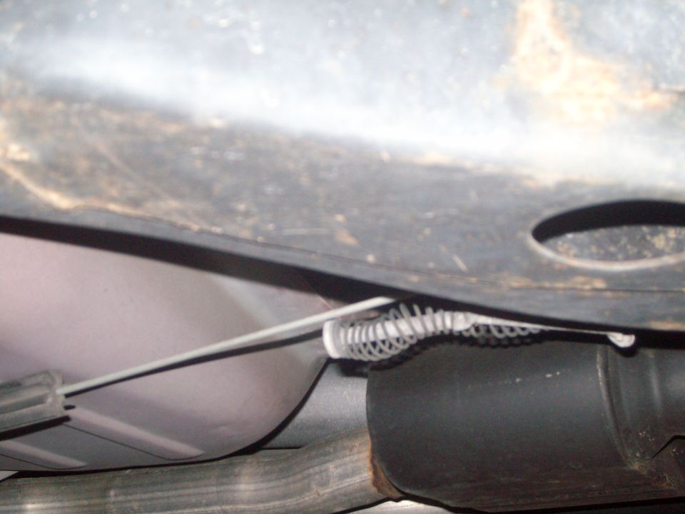 Underbody view of vehicle exhaust pipe and cable mechanism