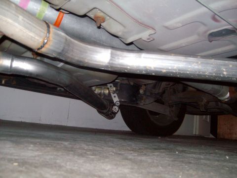 2004 Ford Crown Victoria - Close-up of the exhaust system and rear suspension components of a vehicle.