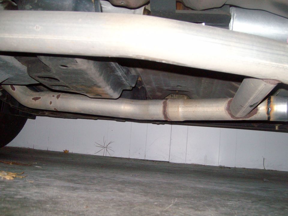 Underbody exhaust pipes and muffler of a car, viewed from below