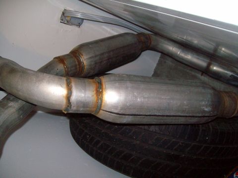2004 Ford Crown Victoria - Close-up view of an exhaust system and a spare tire, likely in a trunk or storage area.