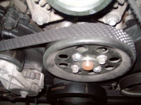 2004 Ford Crown Victoria - Close-up view of the serpentine belt and pulleys within the engine bay of a 2004 Ford Crown Victoria.