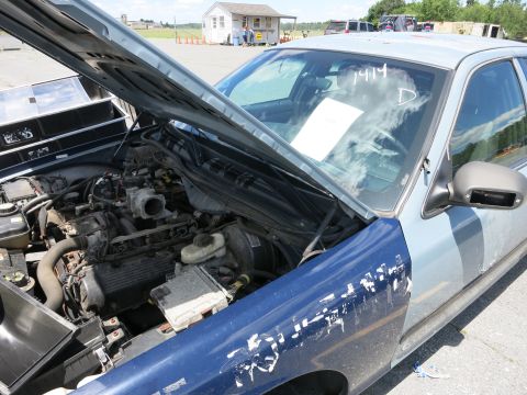1991 Ford LTD Crown Victoria - The engine bay of a car is visible with the hood open, revealing the engine components.
