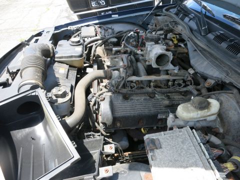 1991 Ford LTD Crown Victoria - The engine bay of a vehicle is shown with various mechanical parts and wiring.