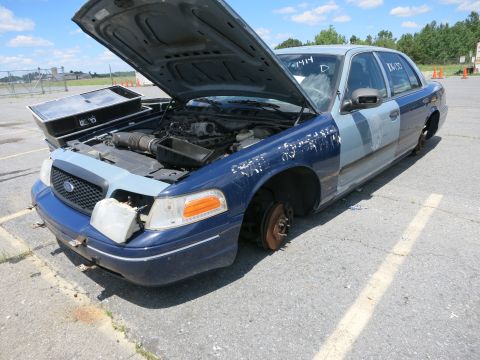 1991 Ford LTD Crown Victoria - This sedan, possibly a Ford Crown Victoria, is missing its wheels and has its hood open, revealing the engine compartment.