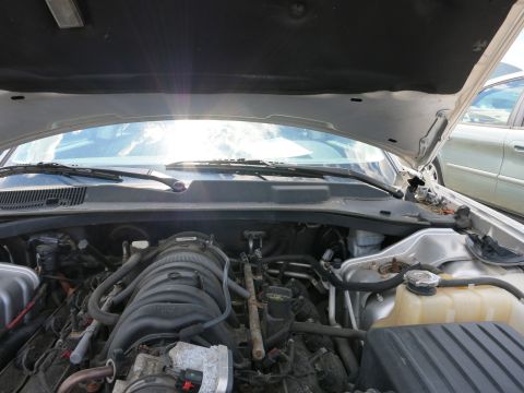 1991 Ford LTD Crown Victoria - The engine bay of a car is visible with the hood open, revealing the engine and surrounding parts.