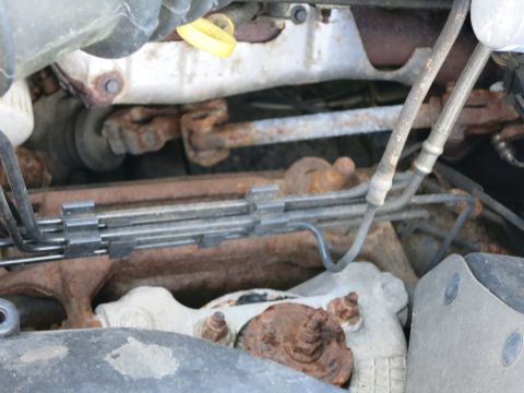 1991 Ford LTD Crown Victoria - Close-up view of a rusty engine bay, showing steering components and brake lines.