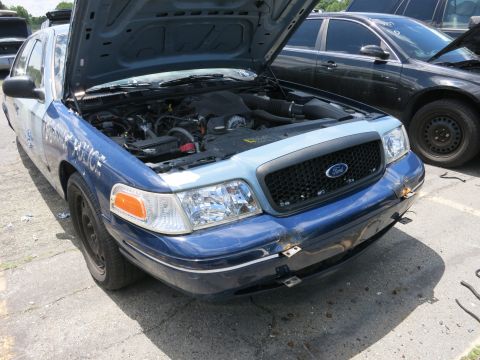 1991 Ford LTD Crown Victoria - A Ford Crown Victoria police car, likely from the 2000s, is shown with its hood up, revealing the engine compartment.