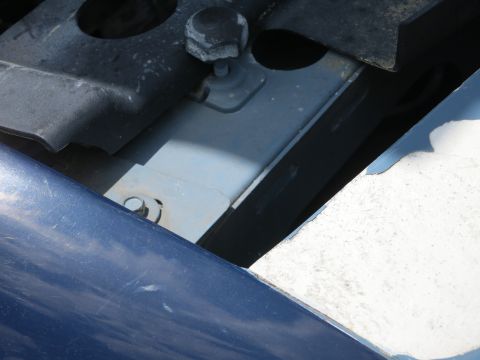 1991 Ford LTD Crown Victoria - Close-up view of the engine bay of a blue vehicle, showing various mechanical parts and fasteners.