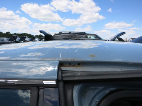 1991 Ford LTD Crown Victoria - The light blue car roof shows signs of wear and tear, with visible rust and scratches under a cloudy sky.