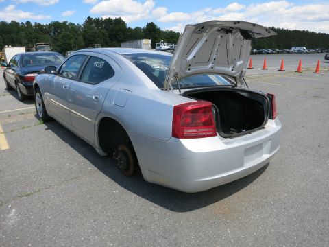 1991 Ford LTD Crown Victoria - A silver sedan is parked in an outdoor lot with its trunk open and one rear wheel removed.