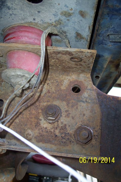 1978 Ford Bronco - This photo shows a rusty vehicle frame with a red suspension component and wiring, dated 06/19/2014.
