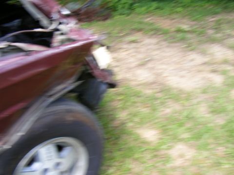 Damaged red SUV front fender and wheel, hood open