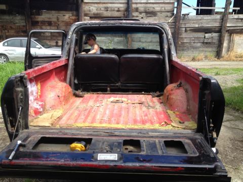 1978 Ford Bronco - The interior and bed of a 1978 Ford Bronco are visible, with a child seated in the back.